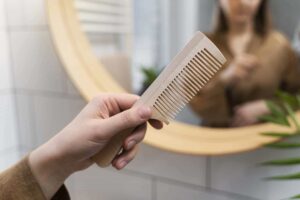 woman holding wooden comb